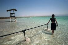 An ultra-Orthodox Jewish boy makes his way into the Dead Sea near Ein Gedi, August 9, 2007.   REUTERS/Yannis Behrakis